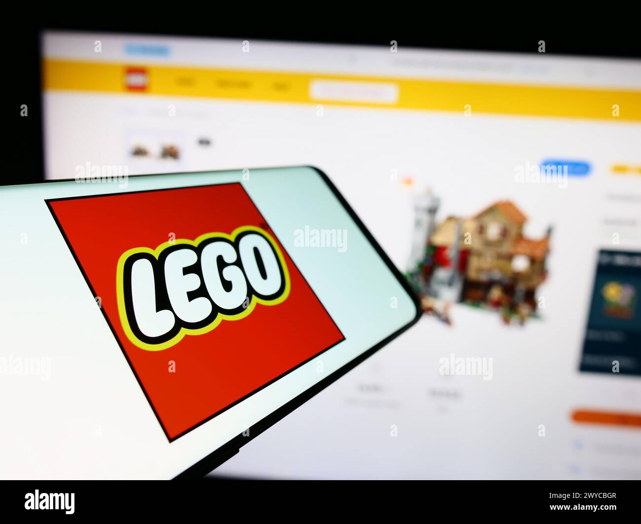 Mobile phone with logo of Danish construction toy company LEGO AS in front of business website. Focus on center-left of phone display. Stock Photo