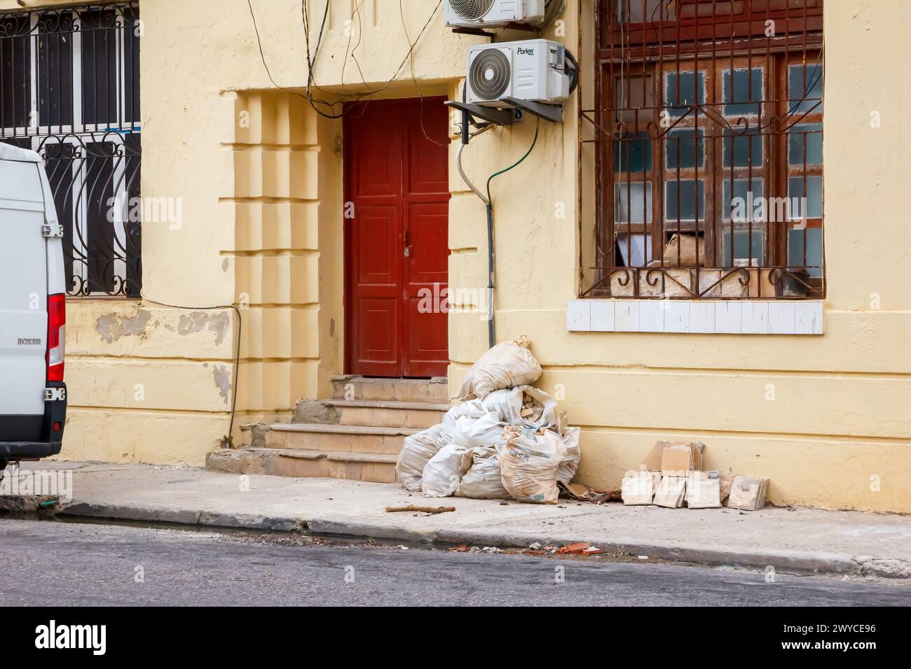 Sacks with rubble by door of building in Havana, Cuba Stock Photo