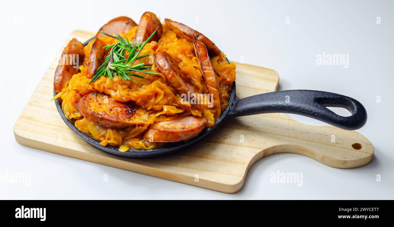 Traditional Polish dish called bigos made of sauerkraut, sausage and mushrooms, food served warm in a cast iron pan Stock Photo
