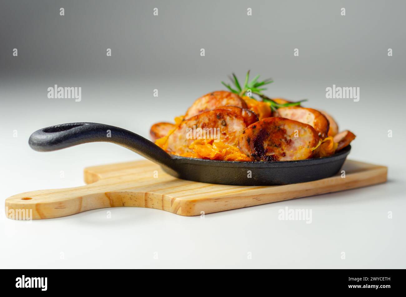 Traditional Polish dish called bigos made of sauerkraut, sausage and mushrooms, food served warm in a cast iron pan Stock Photo