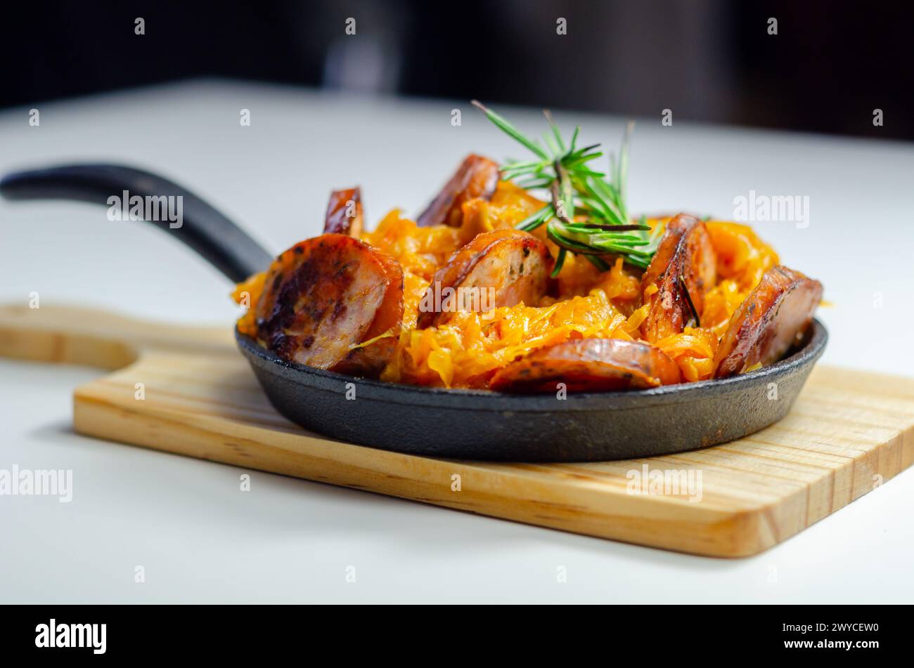 Traditional Polish dish called bigos made of sauerkraut, sausage and mushrooms, food served warm in a cast iron pan Stock Photo