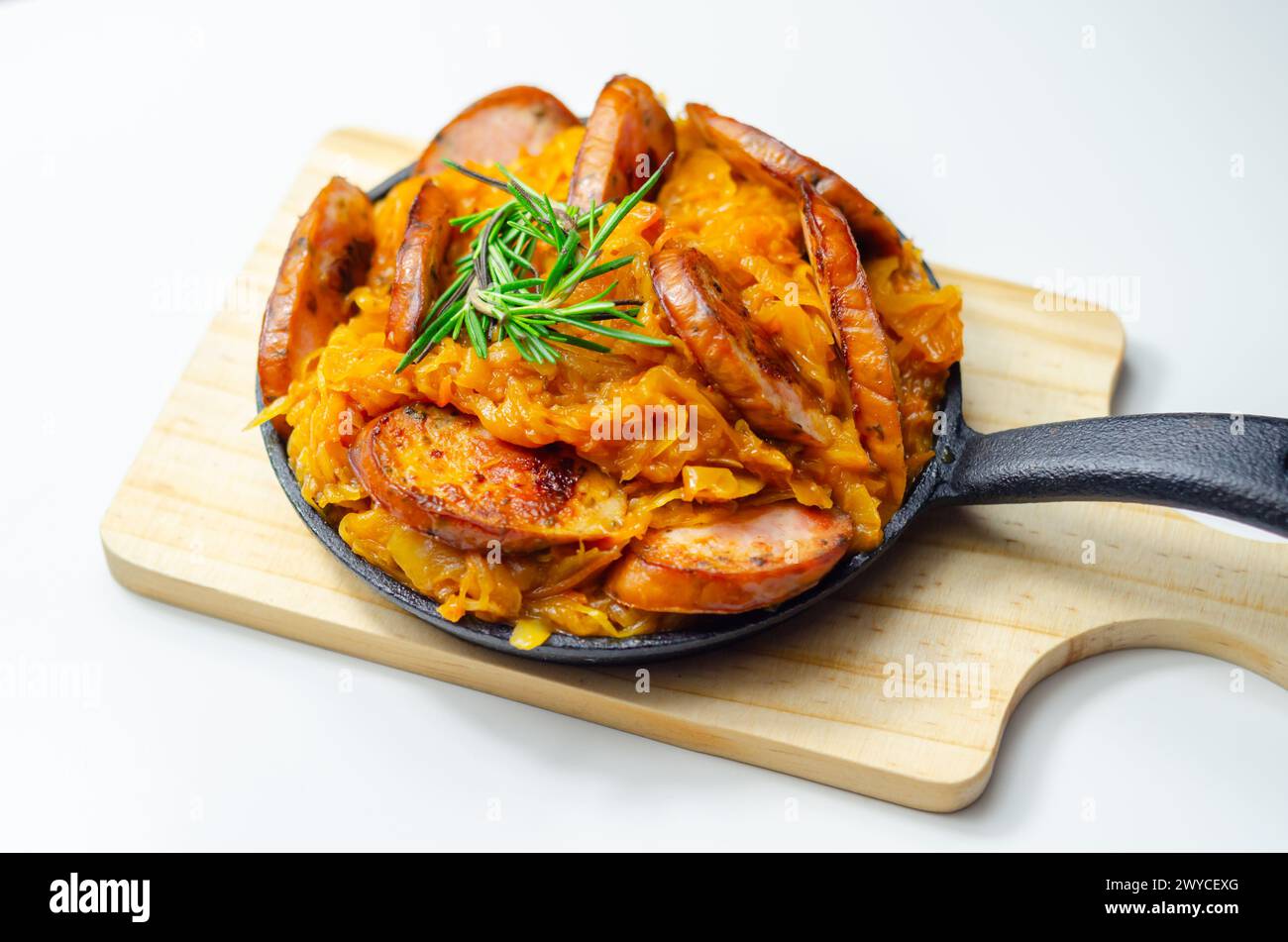 Traditional Polish dish called bigos made of sauerkraut, sausage and mushrooms, food served warm in a cast iron pan Stock Photo