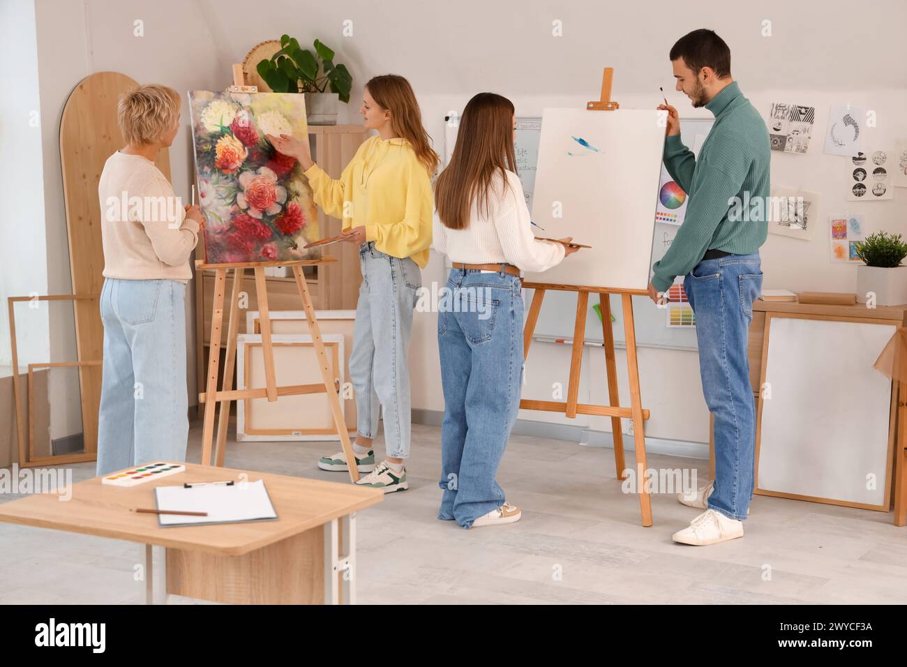 Young students with teacher painting on canvas in art school Stock ...