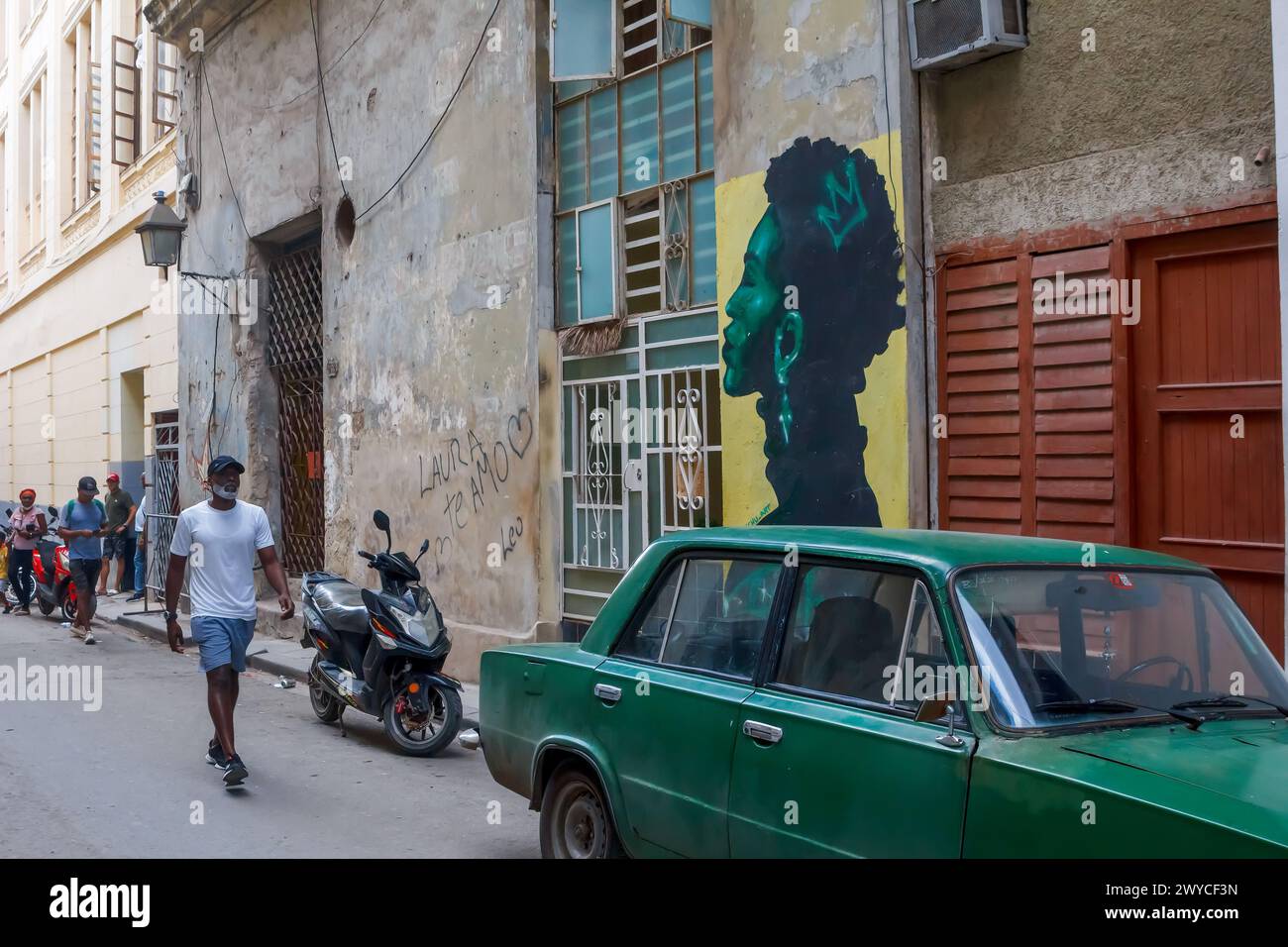 Cuban people and car by a painting graffiti art in Havana, Cuba Stock Photo