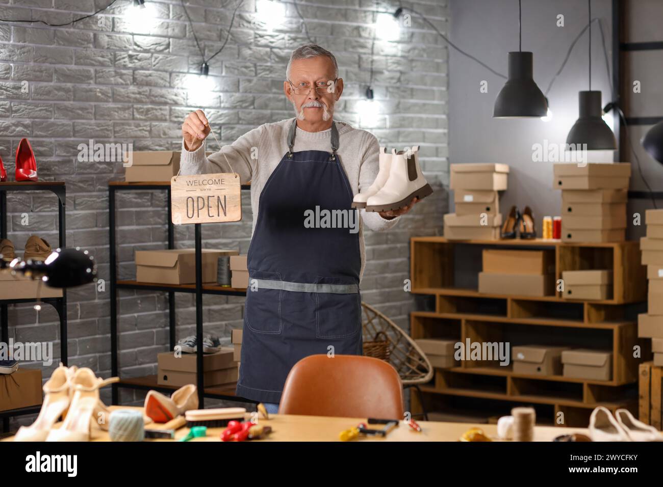 Shoemaker Open Sign Mature shoemaker with OPEN sign and boots in workshop Stock Photo - Alamy
