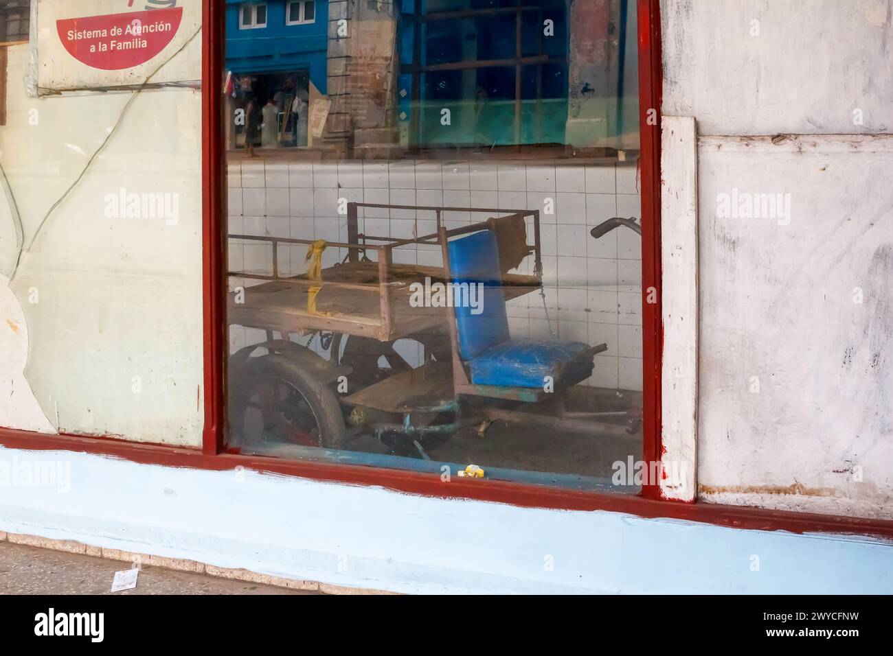 Reflection of a rustic tricycle in a window in Havana, Cuba Stock Photo