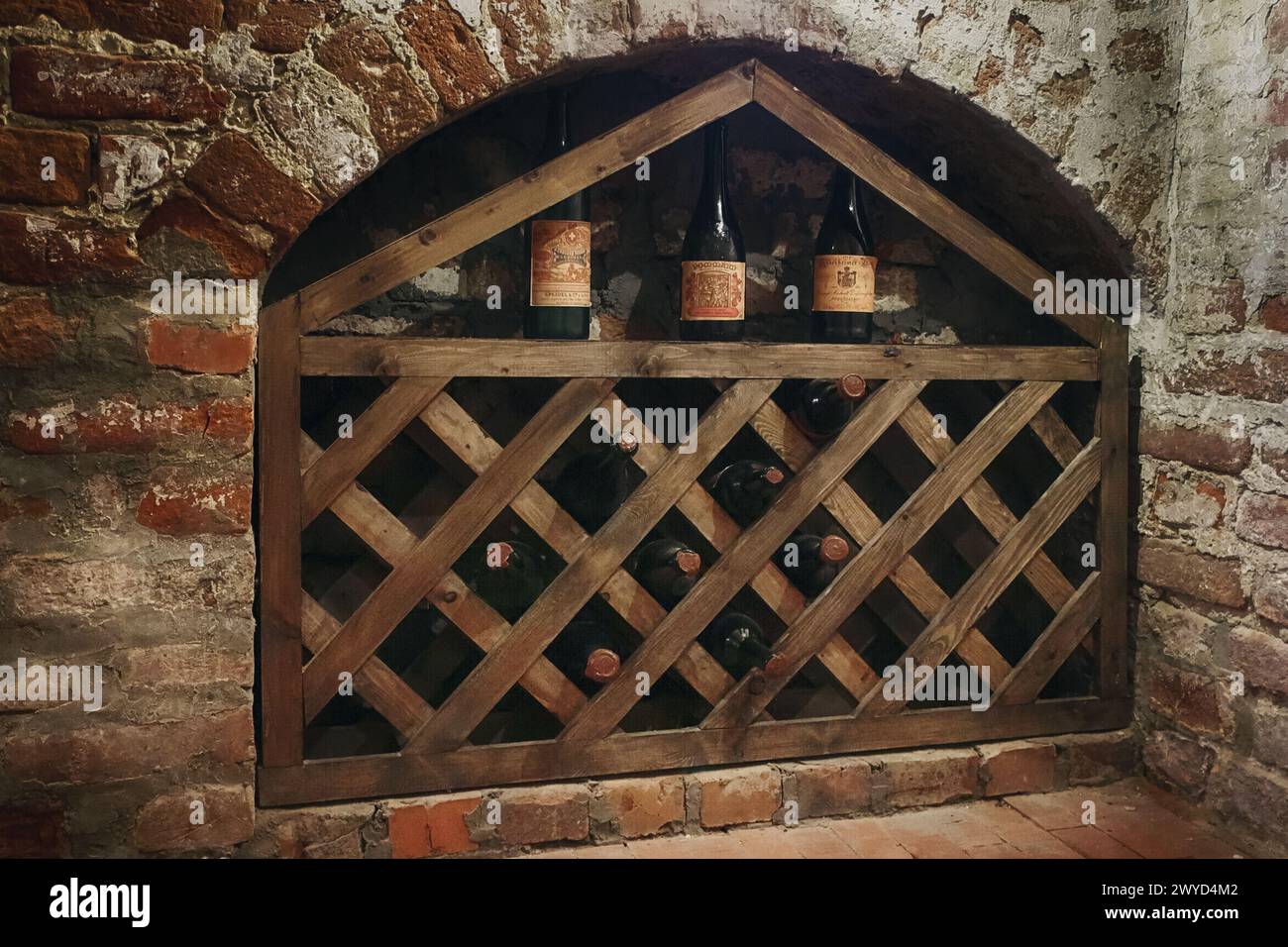 Wine cellar in an old house basement. Different bottles are stored in a room. Shelves are full