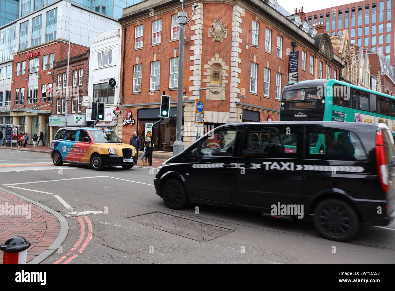 Local taxis driving past each other in Friar Street in Reading Berkshire UK. Charles Dye / Alamy Stock Photo