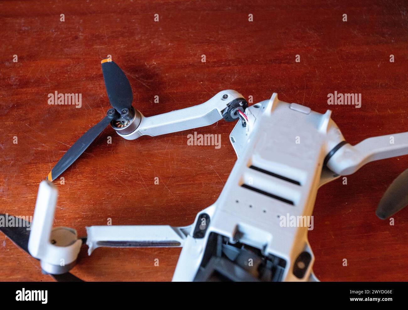 Broken drone (unrecognizable model) on wooden surface. 2 'legs'broken from one side. Drone crashed in Washington DC Stock Photo