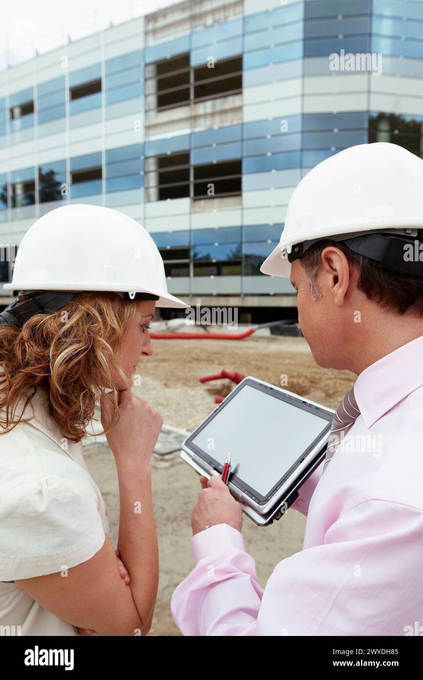 Architect and client with tablet PC in construction site Stock Photo ...