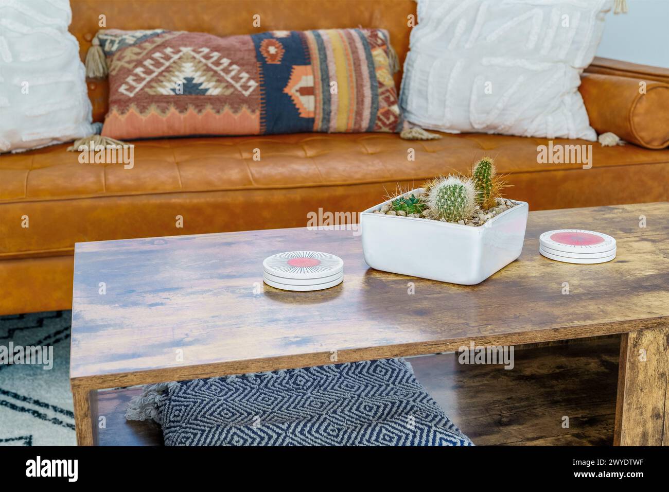 Modern bohemian desert home living room with coffee table leather couch with pillows and cactus Stock Photo