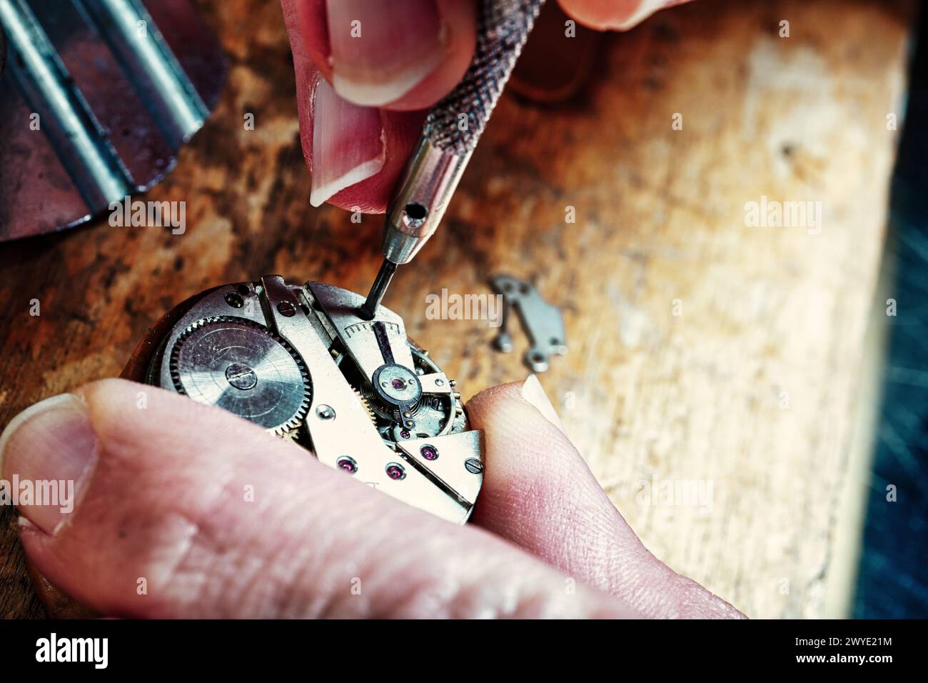 Under the watchful eye of expertise, minute hands and wheels are meticulously guided into place Stock Photo