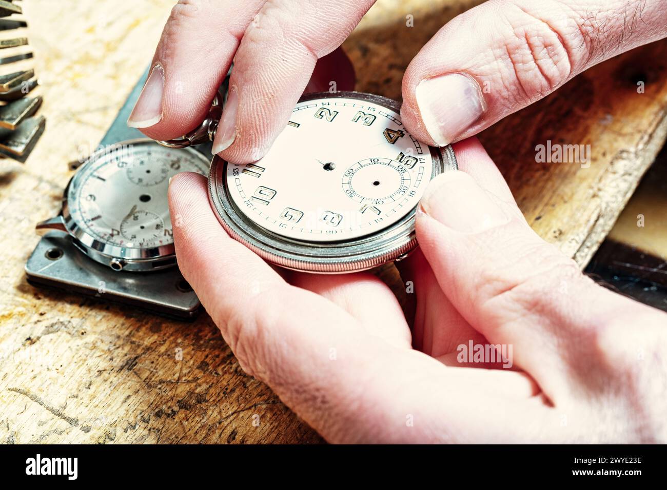 craftsman's fingers adjust the tiny mechanisms within the watch, the essence of punctuality in progress Stock Photo