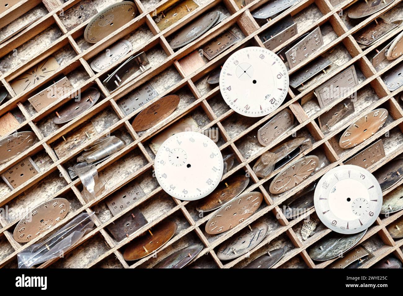 Precisely arranged watch faces in wooden grids stand ready for their mechanical symphony to resume Stock Photo