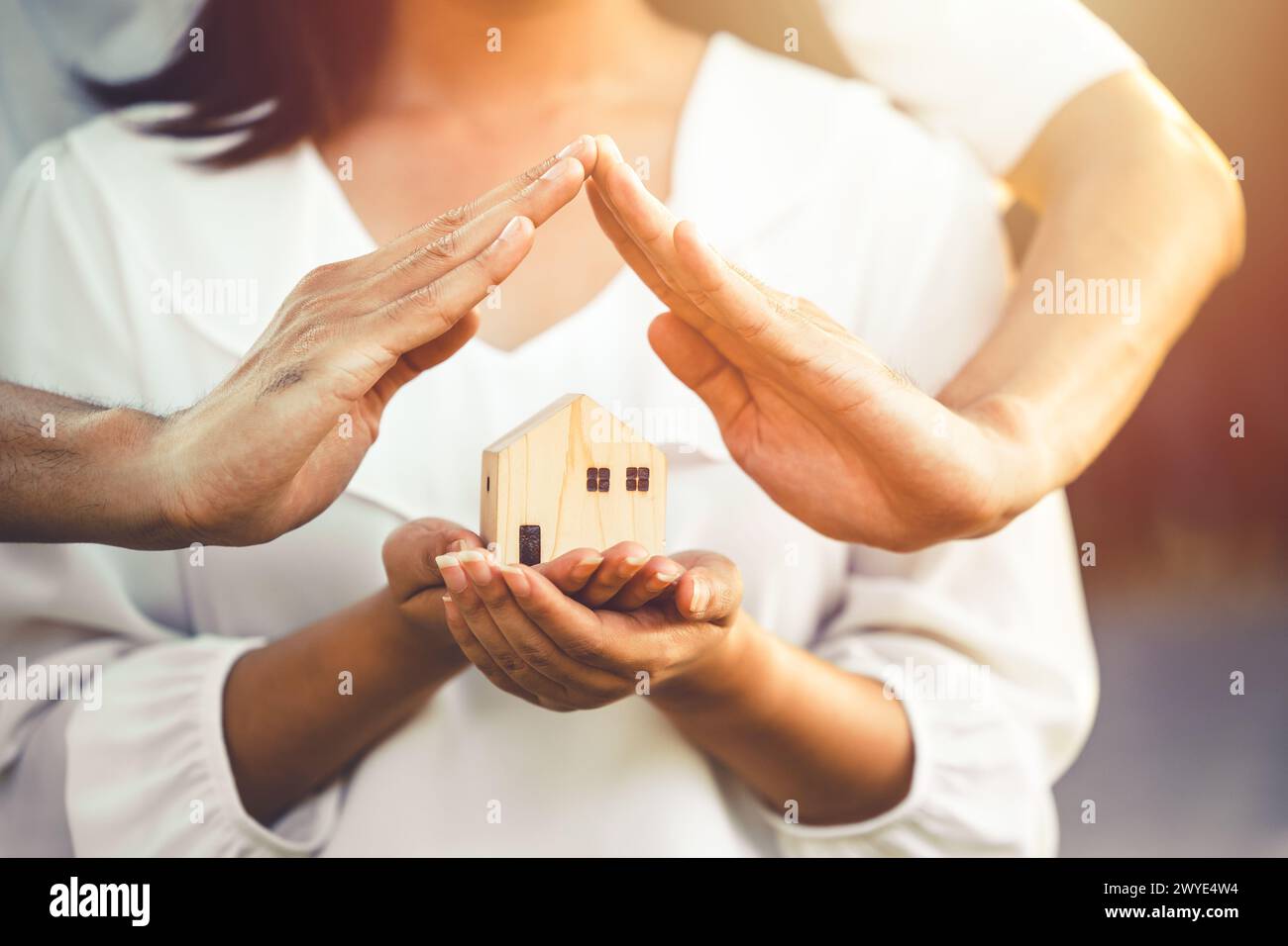 people hand holding miniature wooden house model for banking housing mortgage real estate rent lease home family concept Stock Photo