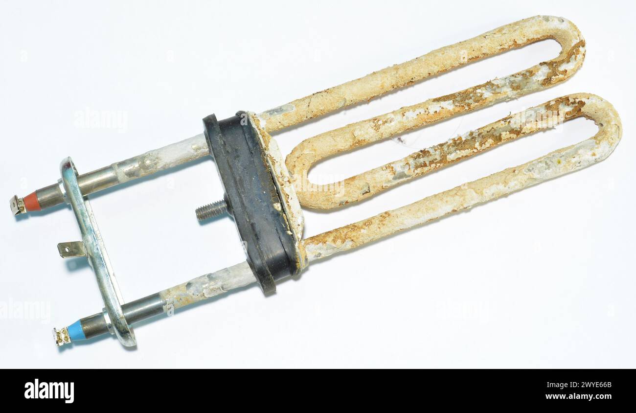 Old broken washing machine heater on white background Stock Photo
