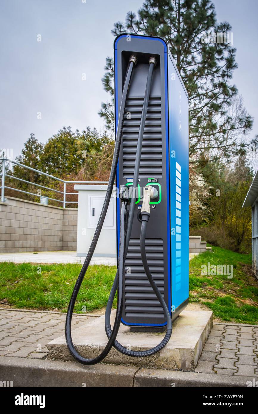 Public car charger at  gas station. Power supply for electric car charging. Stock Photo