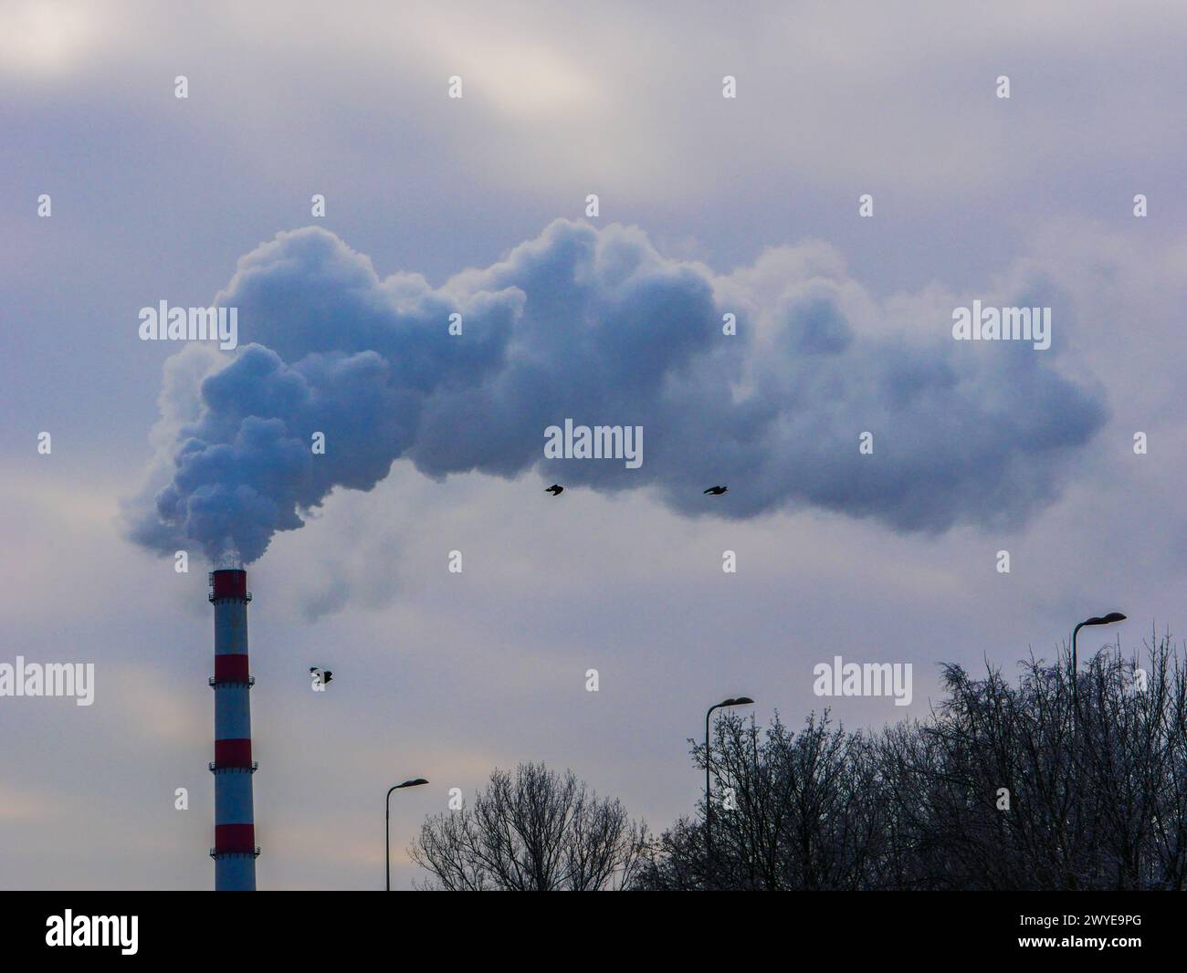 Thick smoke from a factory chimney against a cloudy sky.Smoke pollution ...