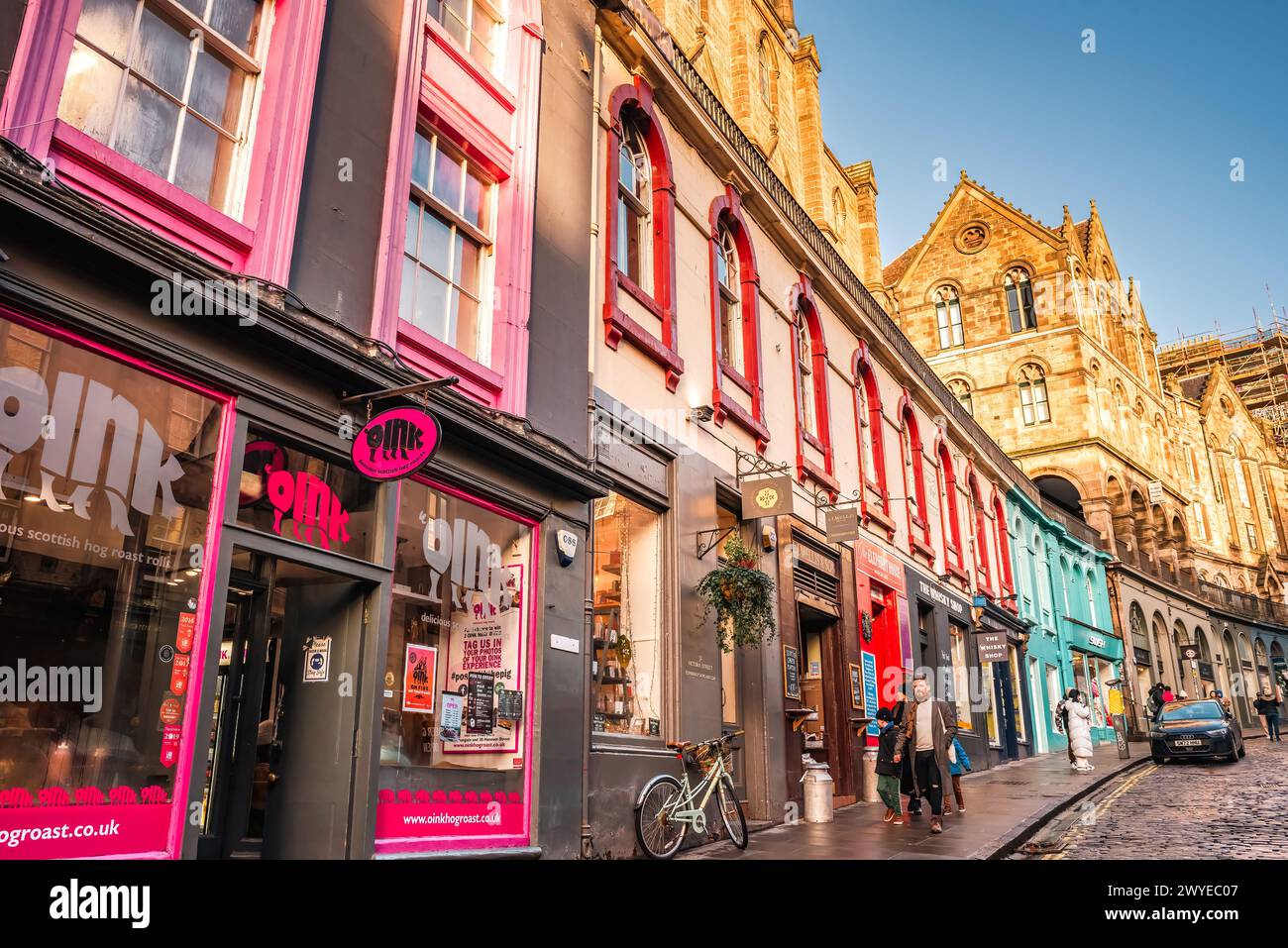 Edinburgh, Scotland - January 22nd, 2024: colorful pink storefront and other painted buildings along West Bow and Victoria Street in Edinburgh Old Tow Stock Photo