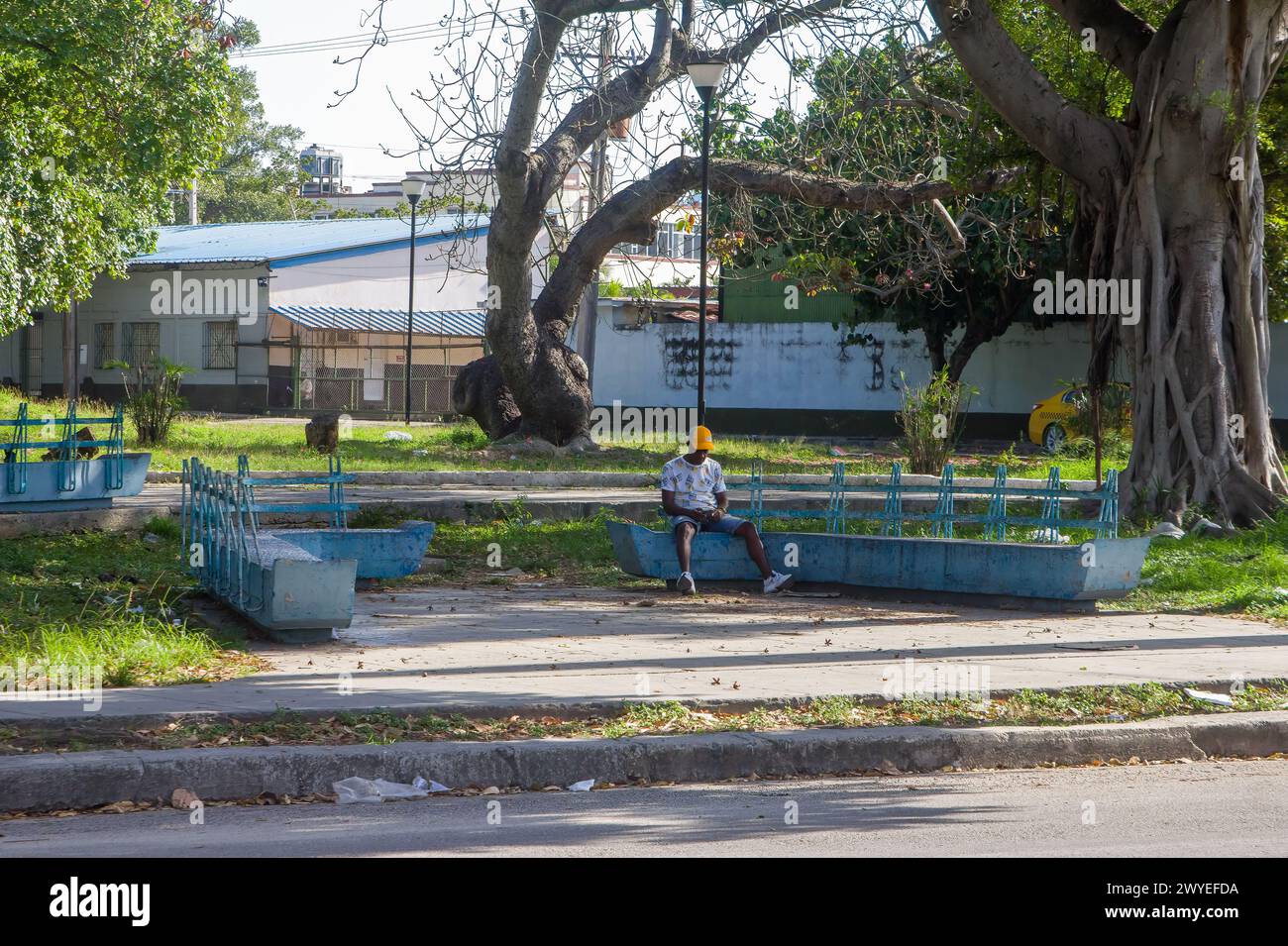 Lonely man sitting on a bench in a square in Havana, Cuba Stock Photo