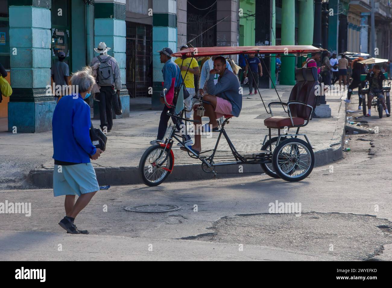 Senior Cuban woman walking on a broken street, city life in Havana, Cuba Stock Photo