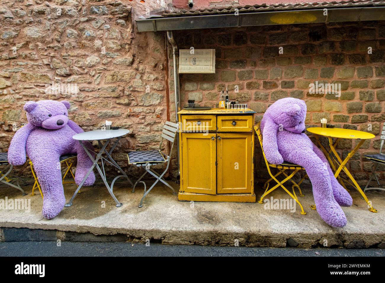 Two purple teddy bears slouch at a bar in Istanbul, Turkey Stock Photo