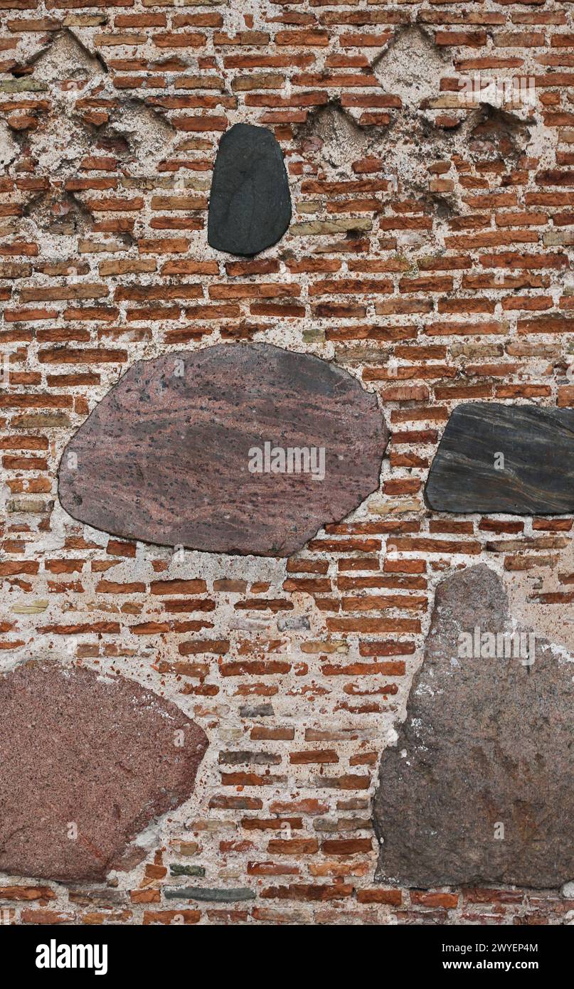 The texture of the old ancient medieval antique stone hard peeling cracked brick wall Stock Photo