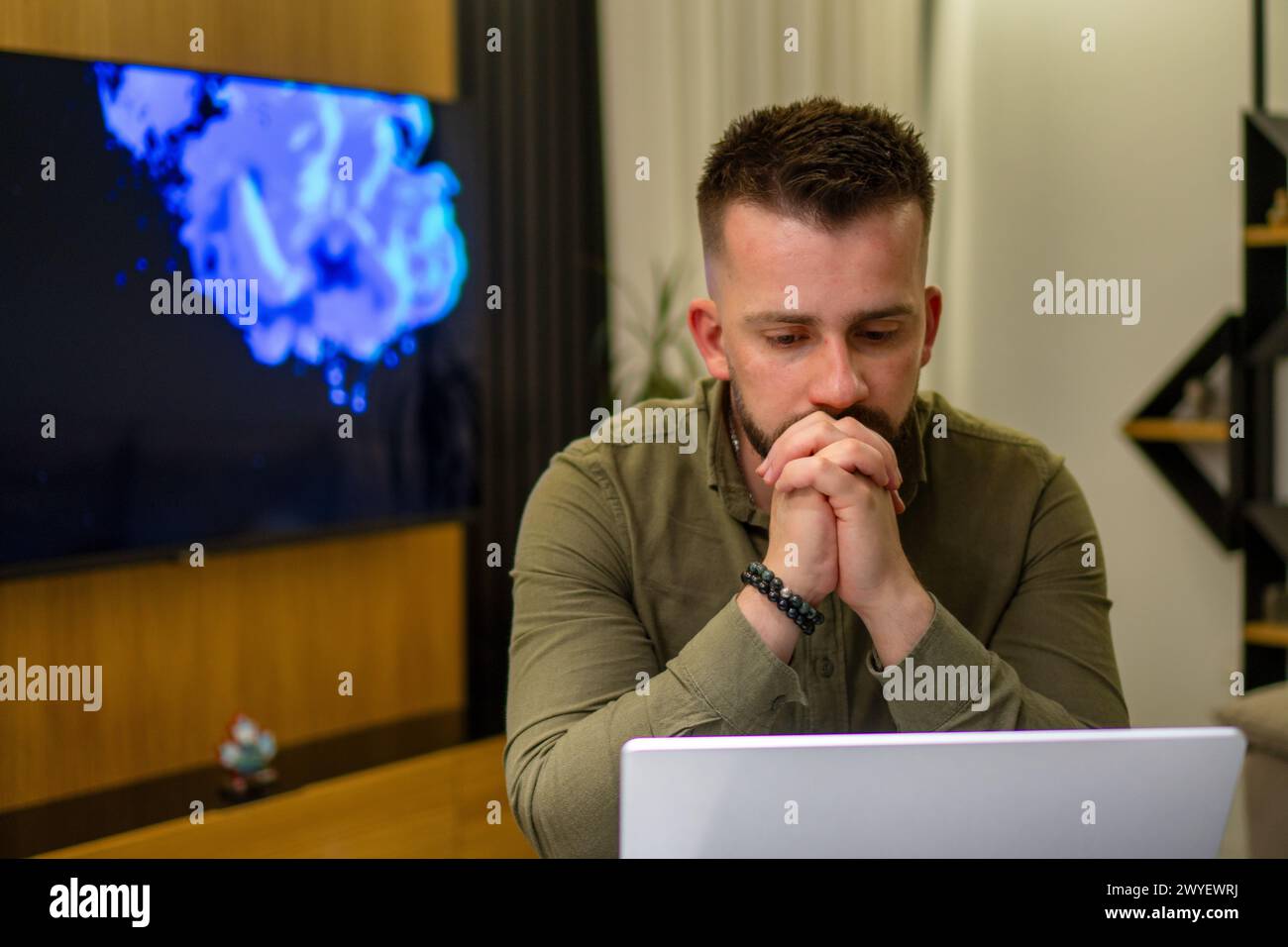 A young bearded Albanian  man working on his notebook from home. Stock Photo