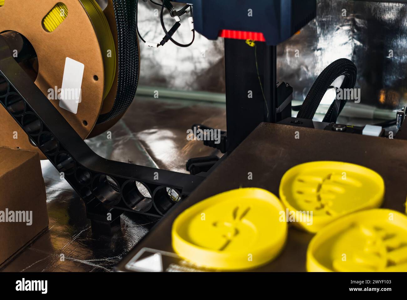 3d printer with some objects on the tray printed with pla filament Stock Photo