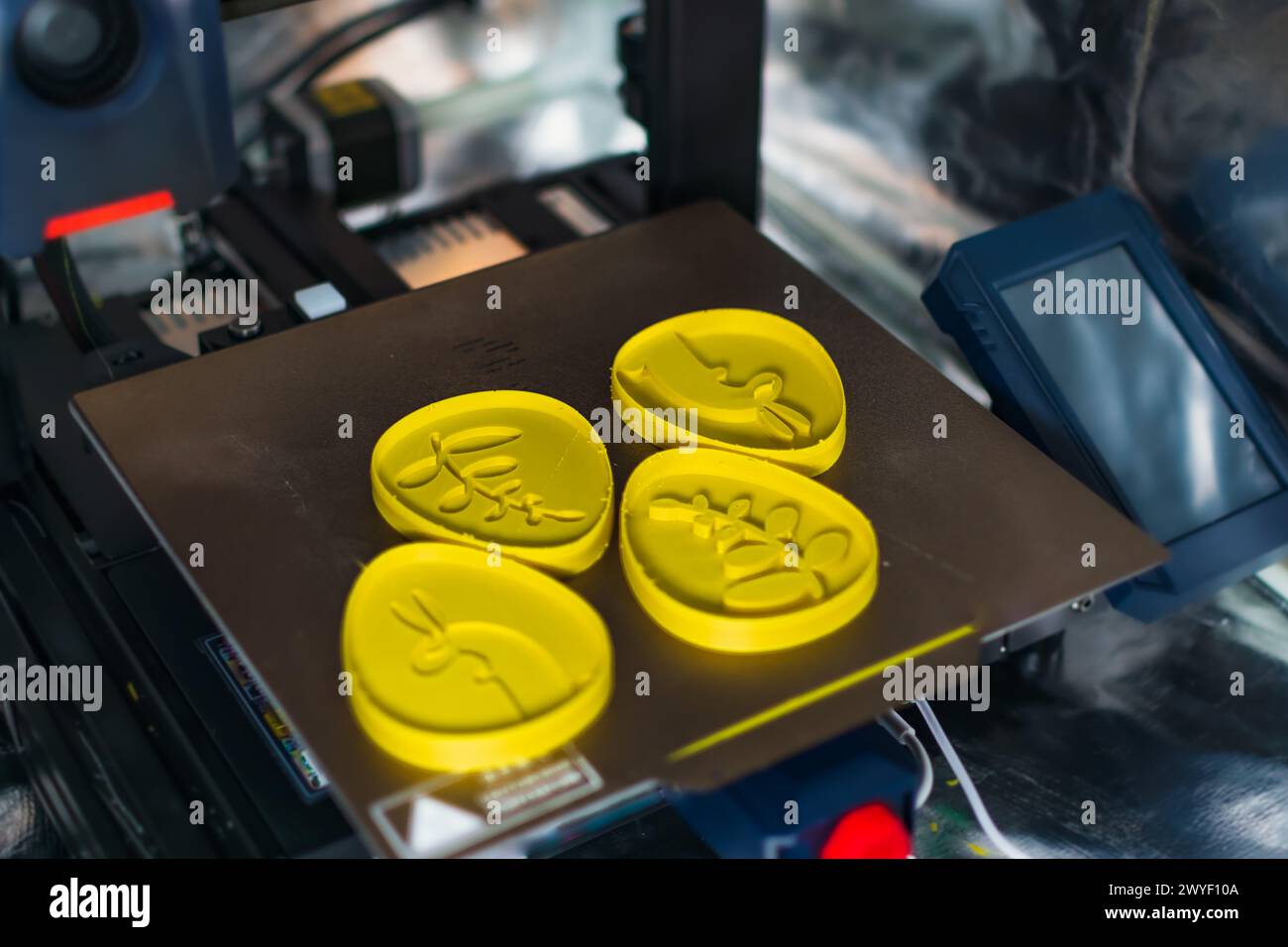 3d printer with some objects on the tray printed with pla filament Stock Photo