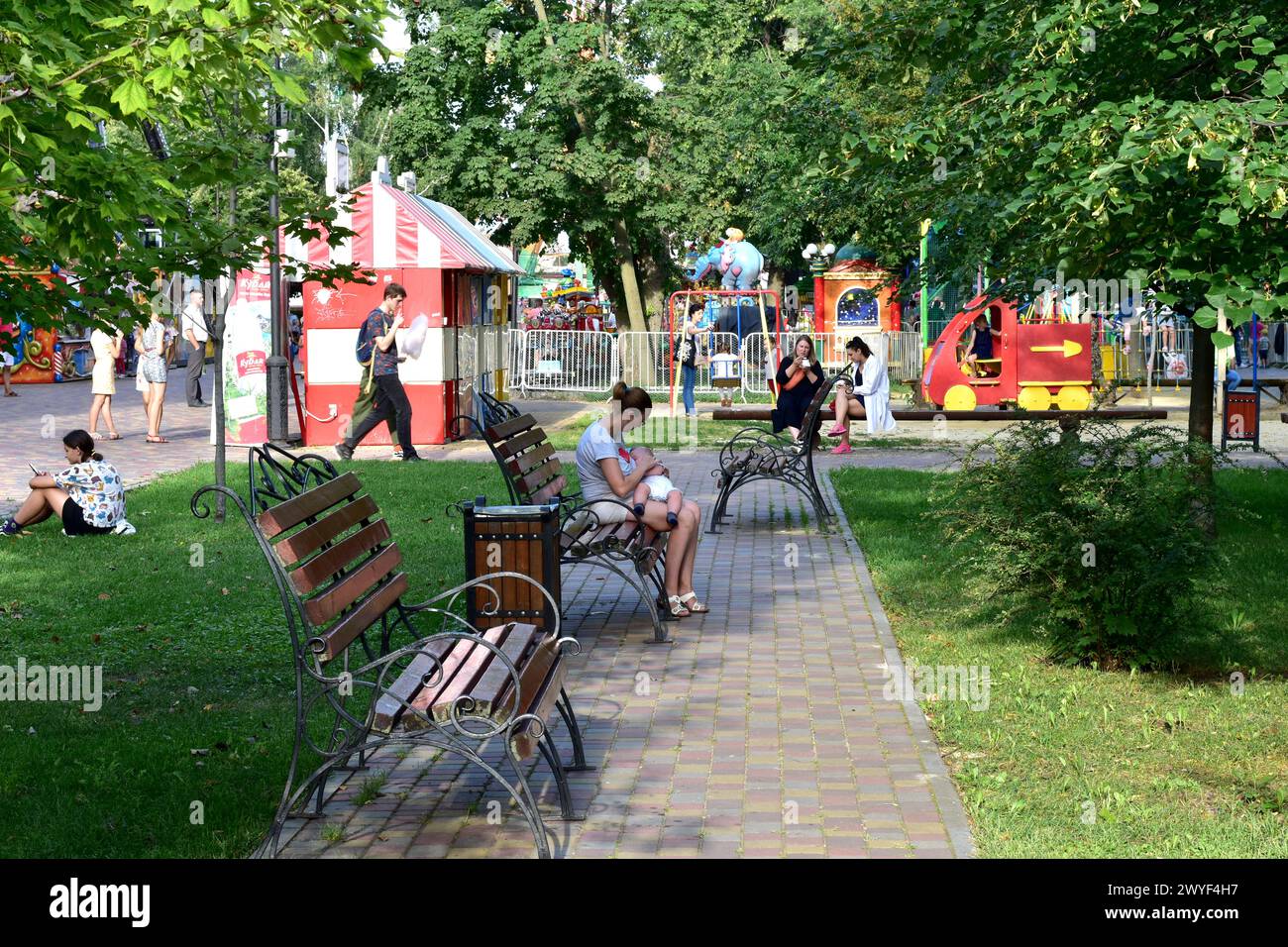 A Woman With A Baby Sits On A Park Bench Stock Photo - Alamy