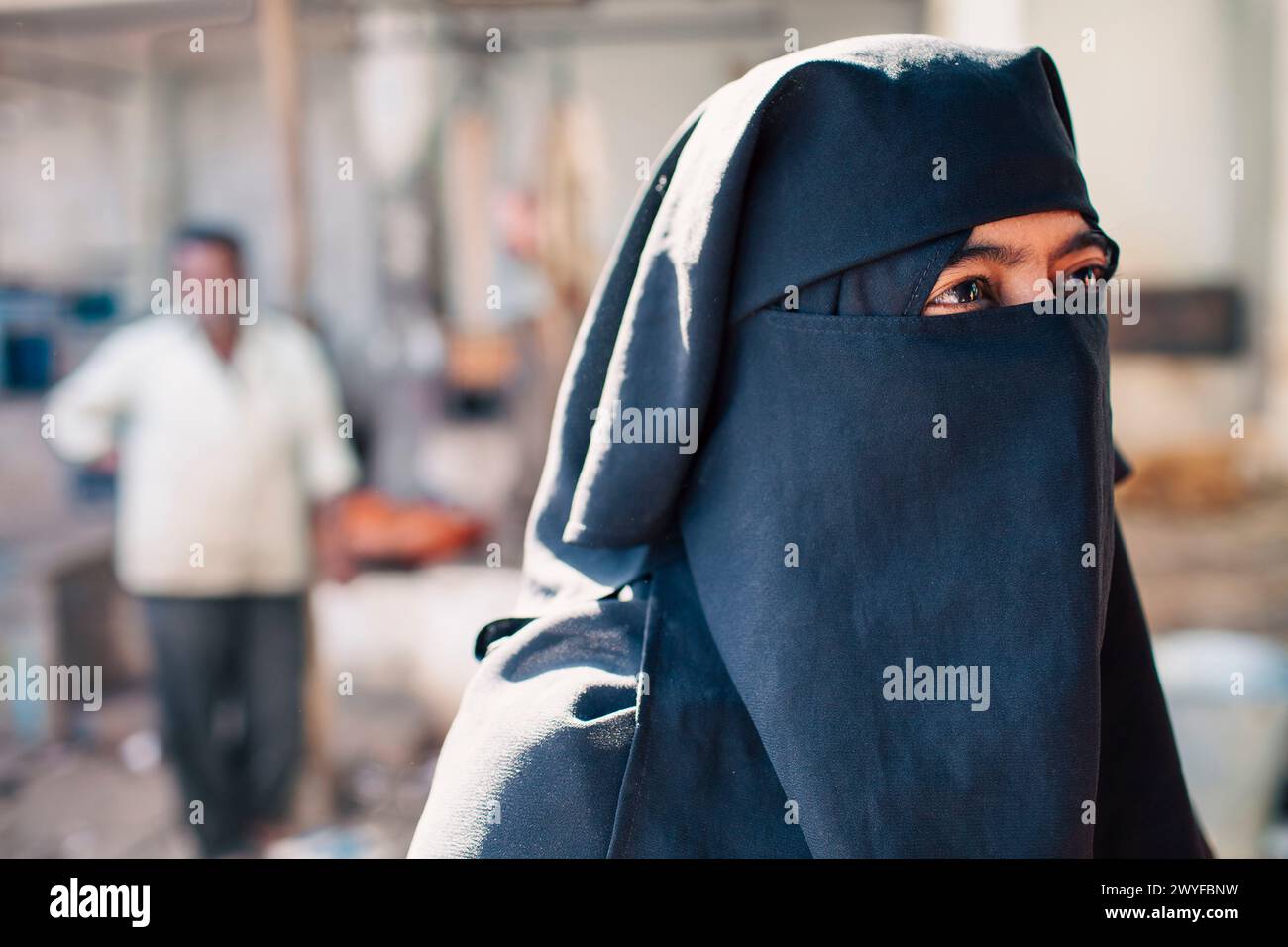 A customer veiled in black, at the butcher s block in Mysore s old market. Street photography in India. Patricia Huchot-Boissier / Collectif DyF Stock Photo