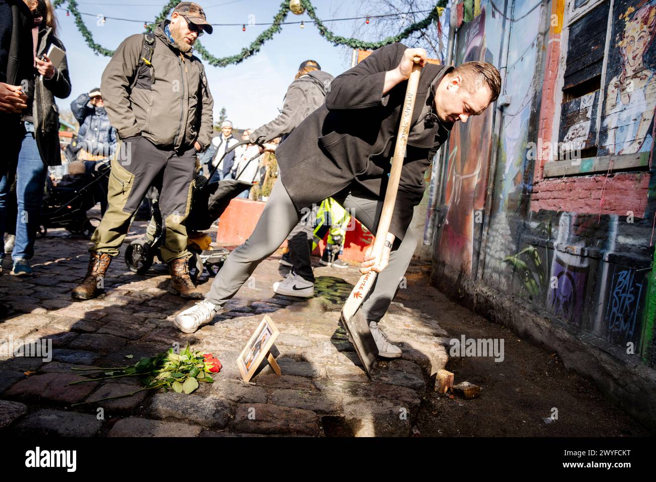 Copenhagen, Denmark. 06th Apr, 2024. A man called Mark digs up a stone at the spot where his brother Lucas was shot and killed as the citizens of the free village Christiania jointly dig up the cobblestones at Pusher Street, in Copenhagen, Denmark, Saturday April 6, 2024. Credit: Ritzau/Alamy Live News Stock Photo