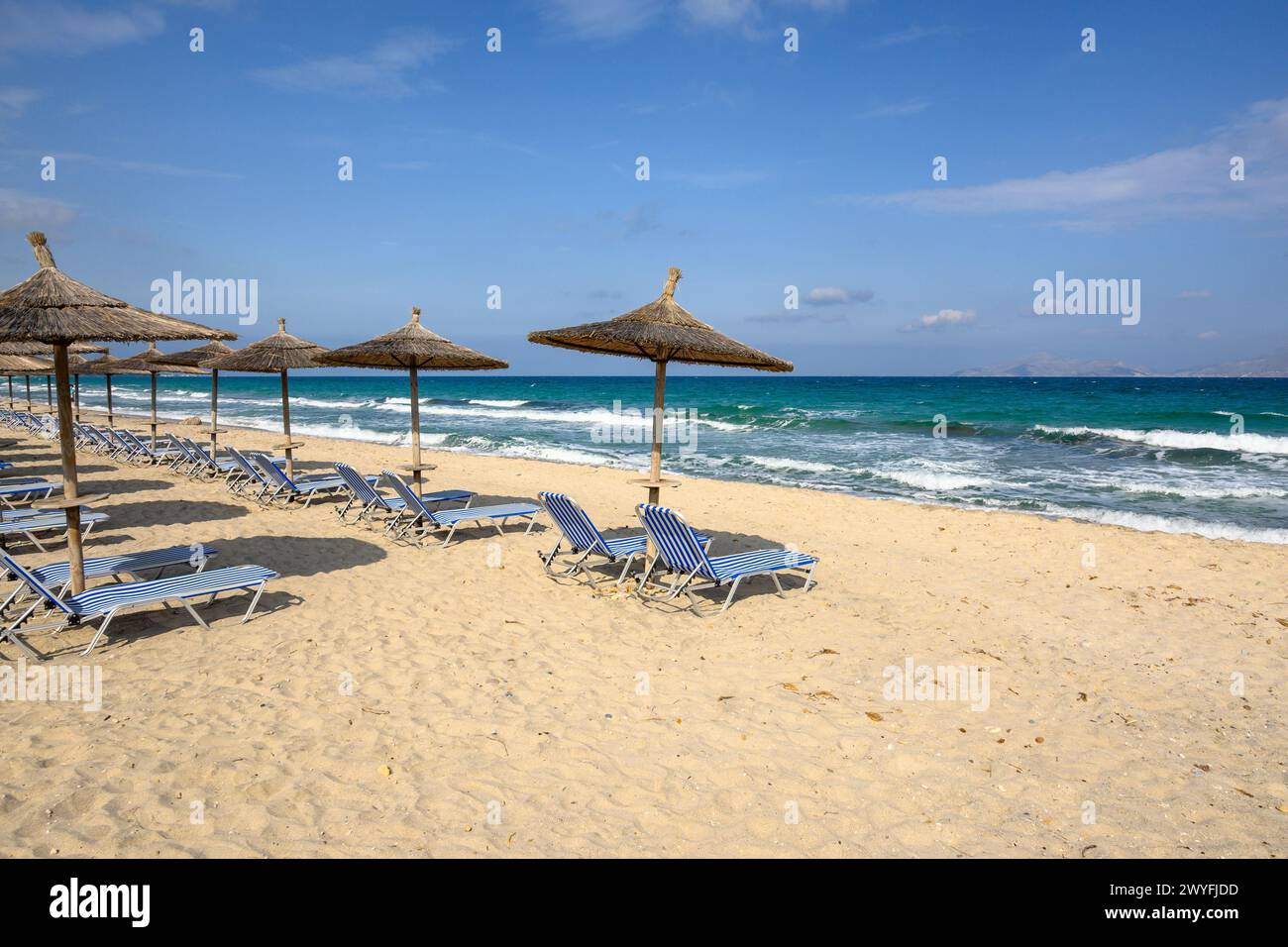 Sunbeds with umbrella on sandy beach of Marmari. The Greek island of Kos Stock Photo