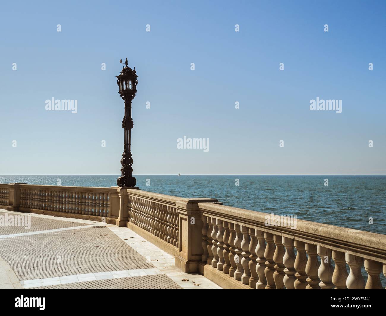 View of the seaside beach promenade of Cadiz with a lantern during a summer vacation, sea view, blue horizon, sunshine Stock Photo