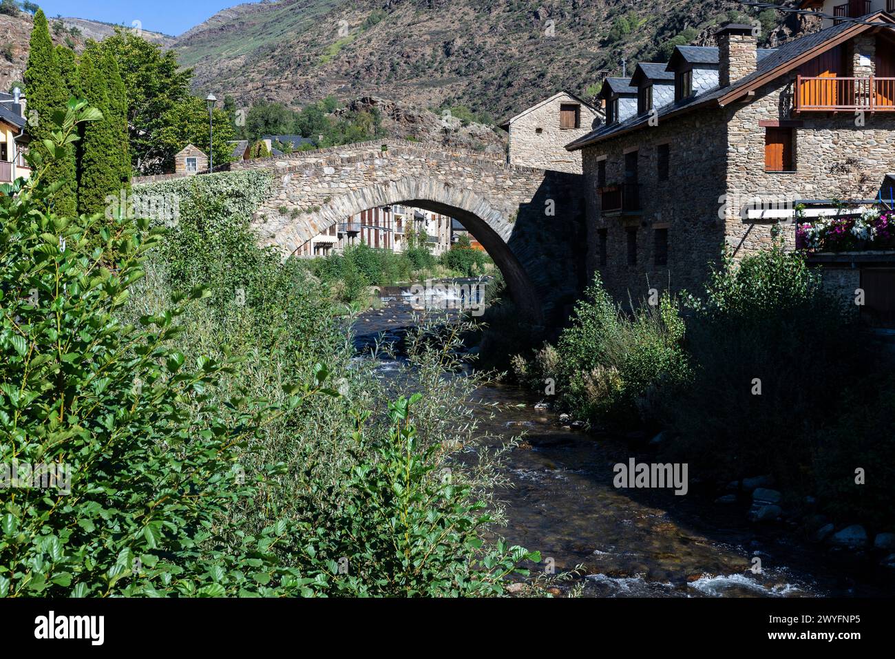 Typical houses and the Romanesque bridge over the Noguera Pallaresa river of the rustic village of Esterri Aneu, Lleida, Catalonia, Spain Stock Photo