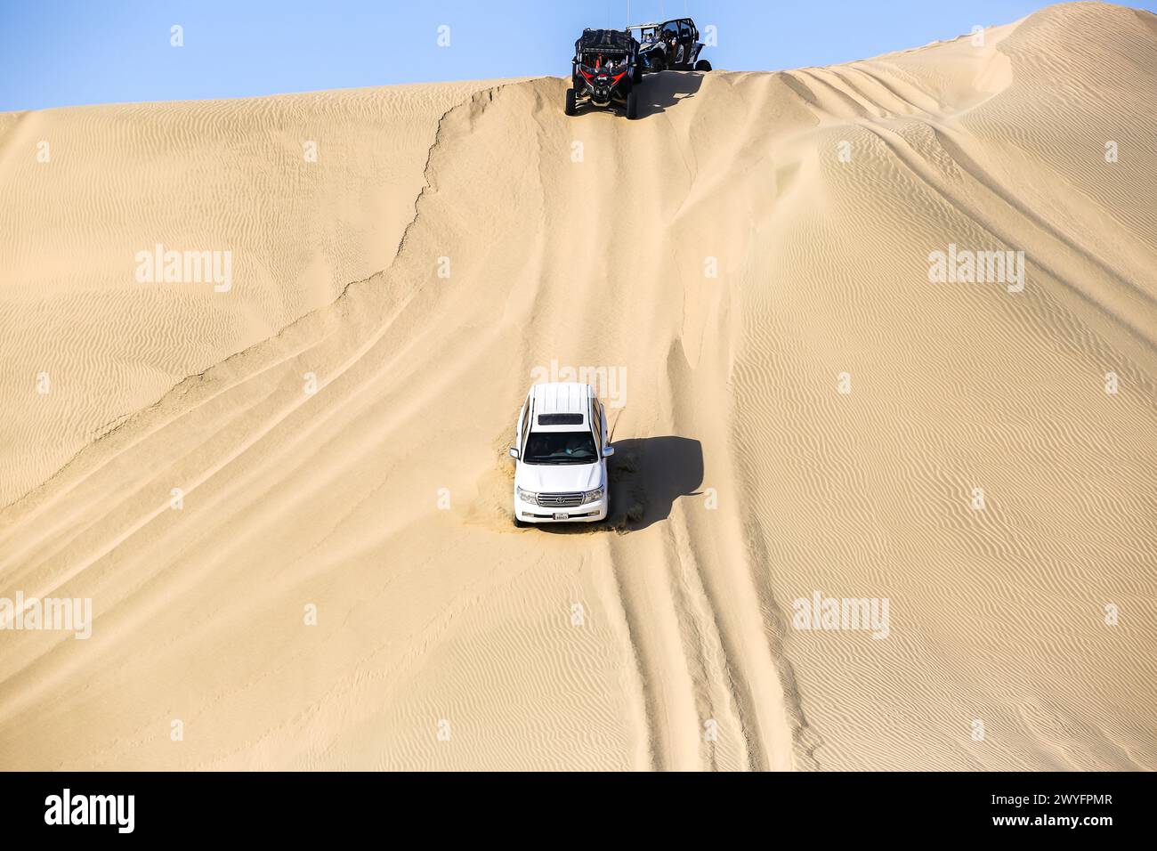 Cars being driven through inland sea desert. Driving their 4x4 cars to desert during weekends is enjoyed by many. Stock Photo