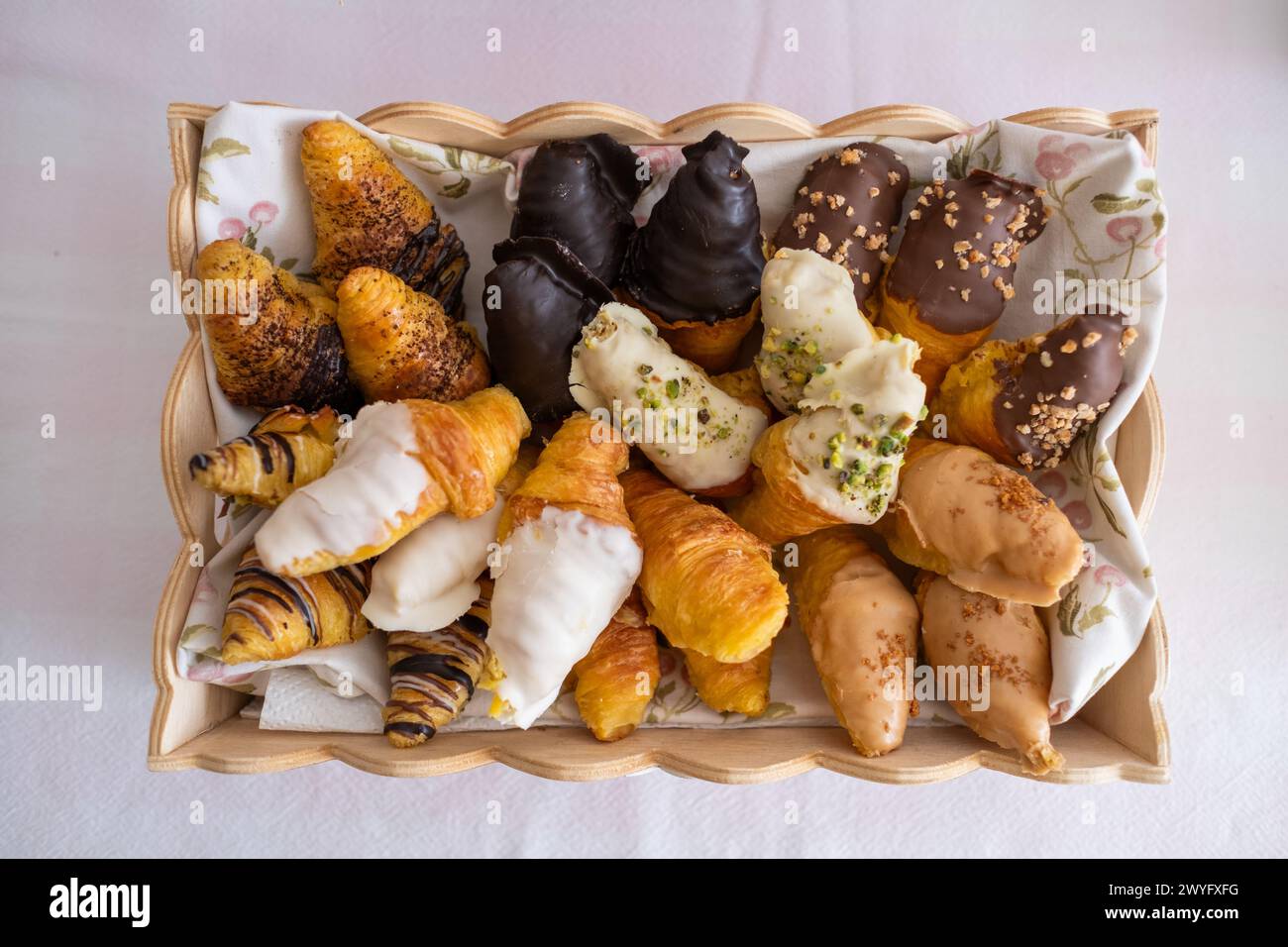 Top view of a tray filled with Easter croissants on an Easter candy table. Typical Easter sweets on a festive celebration table with Easter eggs, choc Stock Photo