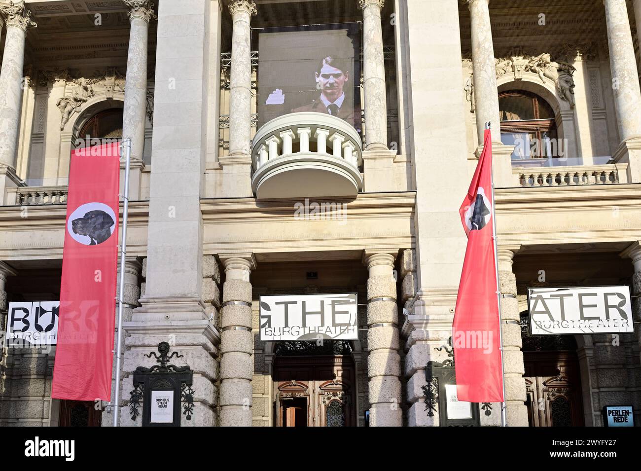Vienna, Austria. 06th Apr, 2024. The Vorarlberg artist and musician Wolfgang Flatz adapted Hitler's Pearl Speech from 1938 for an action in and in front of the Burgtheater in Vienna. Instead of the swastika, there is a dog's head in the middle of the red flags. Credit: Franz Perc/Alamy Live News Stock Photo