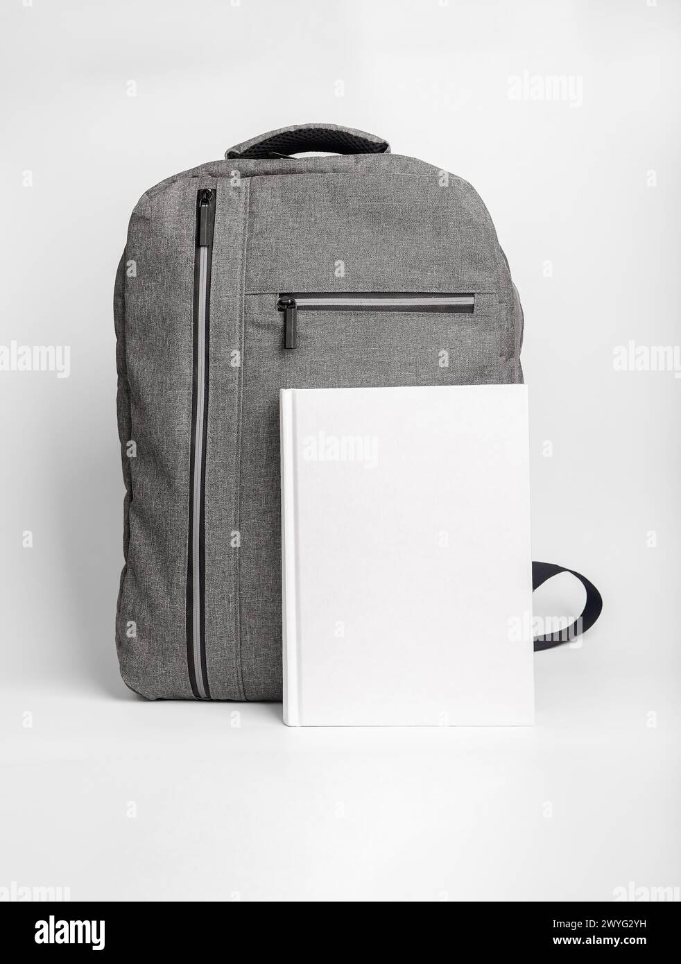 Book cover mockup, textbook mock up at school bag, backpack. Stock Photo