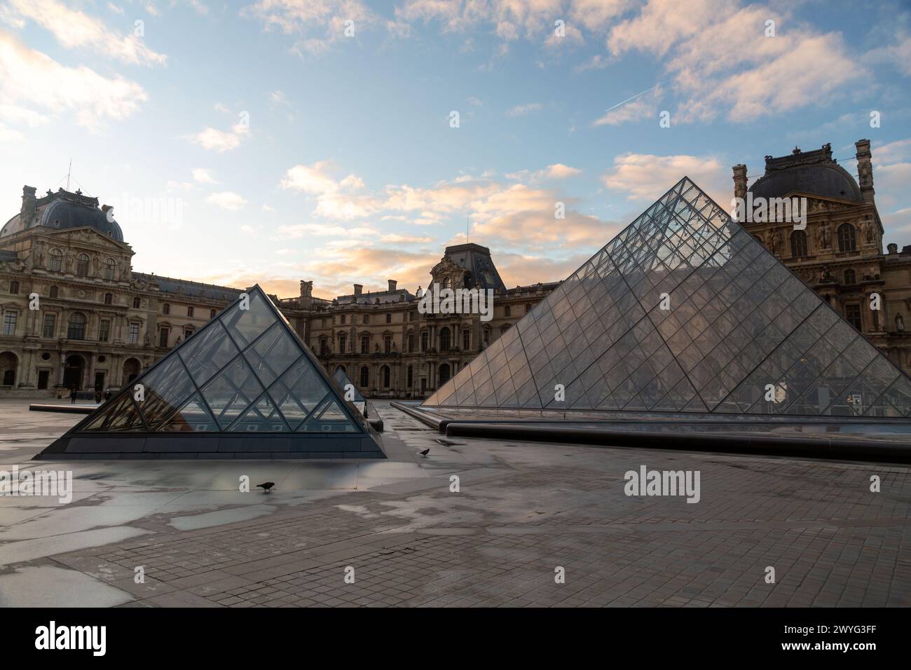 Paris, France - JAN 20, 2022: The glass pyramid of Louvre Museum, the main entrance to famous museum and gallery, completed in 1989. Stock Photo