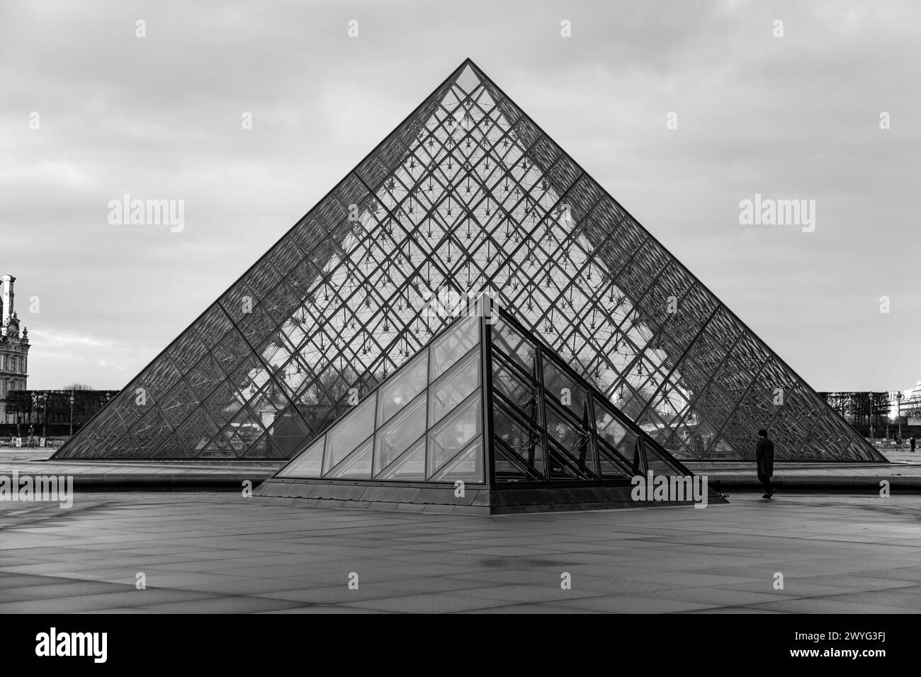 Paris, France - JAN 20, 2022: The glass pyramid of Louvre Museum, the main entrance to famous museum and gallery, completed in 1989. A beautiful winte Stock Photo