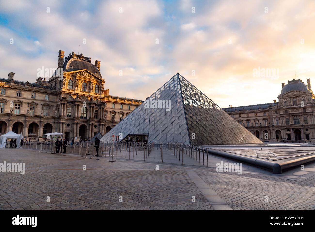 Paris, France - JAN 20, 2022: The glass pyramid of Louvre Museum, the main entrance to famous museum and gallery, completed in 1989. A beautiful winte Stock Photo