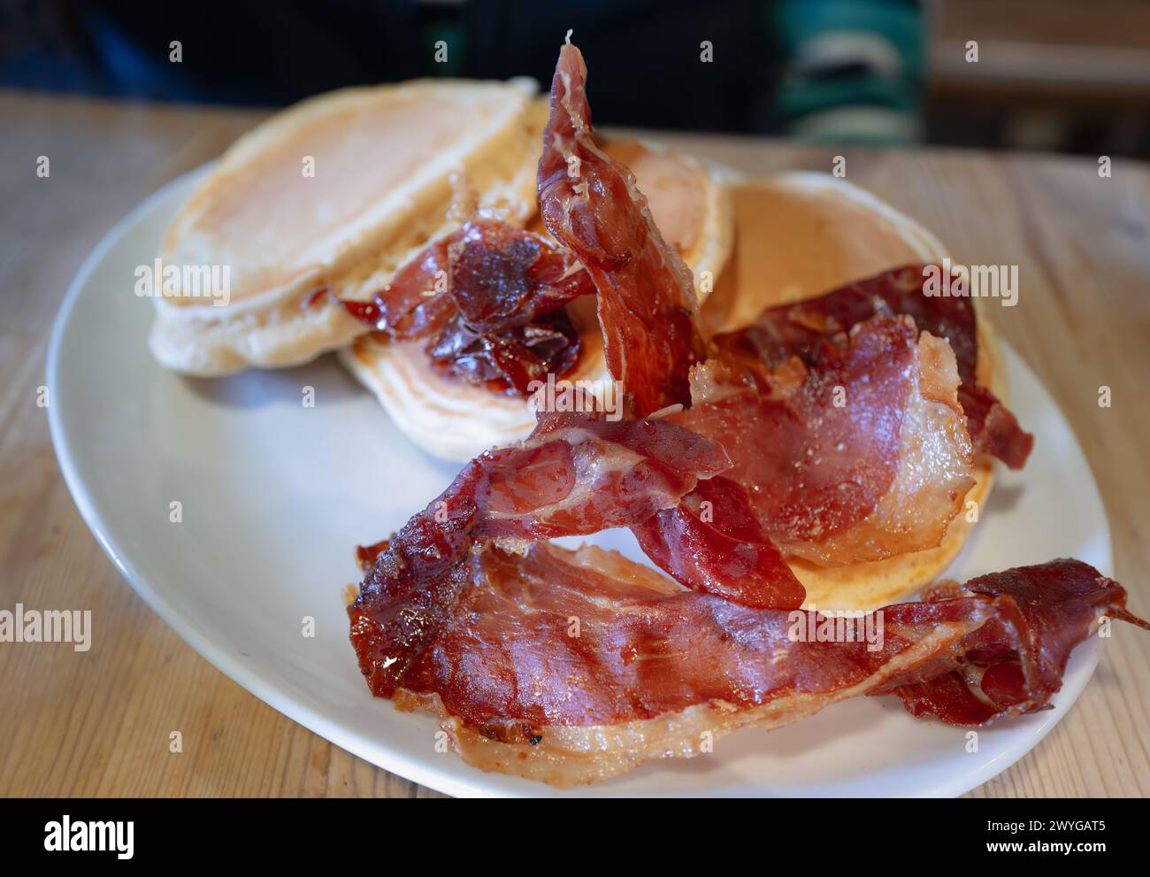 Crispy ham and panckaes on a white oval plate. Stock Photo