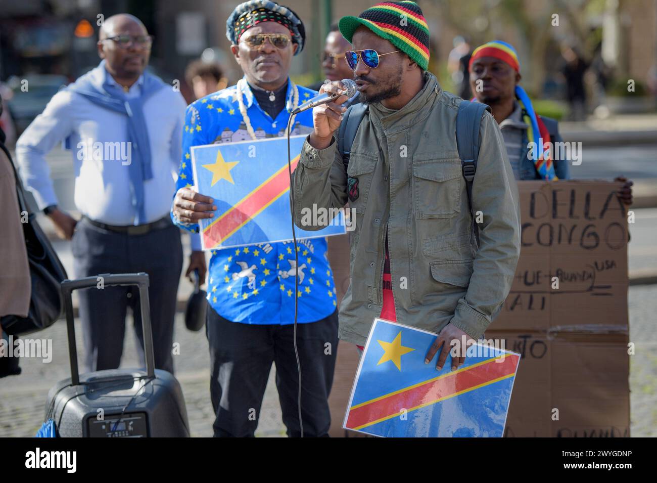 April 6, 2024, Rome, Italy: A man displays the Congo flag while speaking into the microphone during the demonstration to express solidarity with the Congolese people, to ask for a 'stop to the ongoing genocide' and an end to the exploitation of the African continent organized by some associations of the African communities of Europe together with the Communist Network and the Hands Off from Africa movement in Rome.According to the organizers, the 30 years of armed conflict financed by the Western war industry have caused the death of 15 million civilians and 7 million displaced people in one o Stock Photo