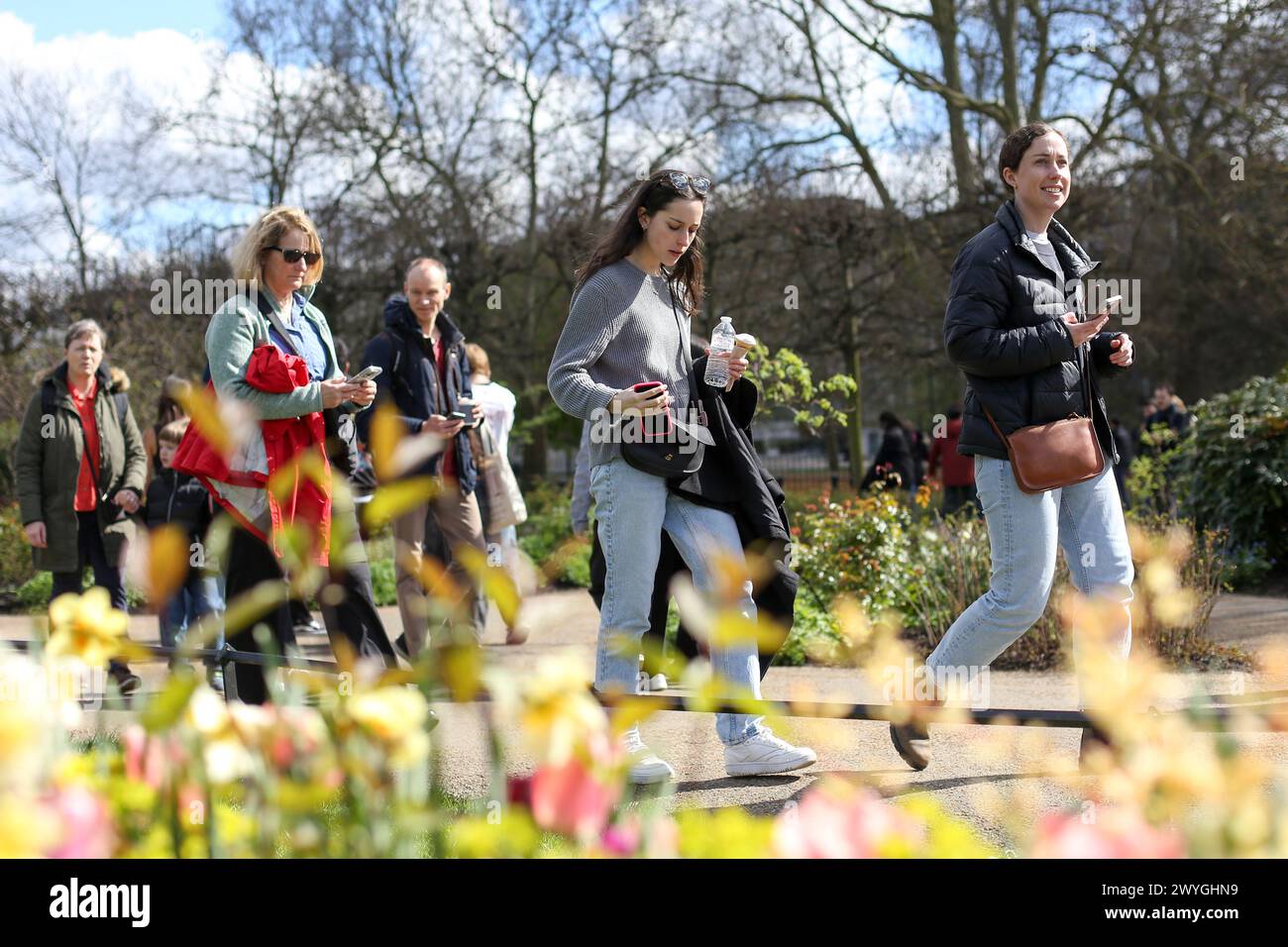 London, UK. 30th Mar, 2024. People walk past spring flowers in Hyde Park in London on a sunny spring day. Weather forecasters are expecting warmer temperature over the next few days. (Photo by Steve Taylor/SOPA Images/Sipa USA) Credit: Sipa USA/Alamy Live News Stock Photo
