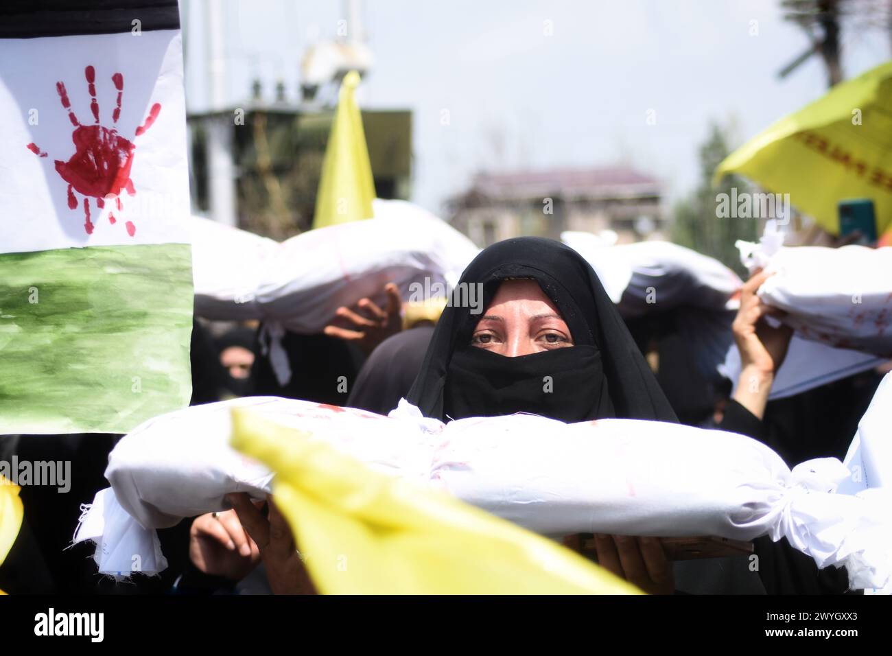 Kashmiri Women Carrying White-shrouded Body Bags Representing Victims 