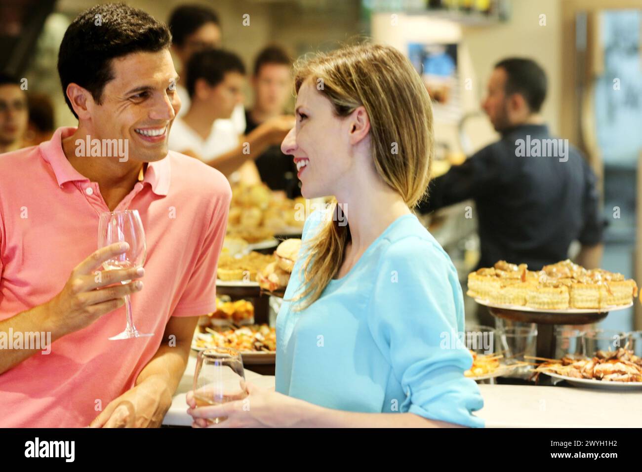 Couple drinking wine and eating tapas. Pintxos. Bar txondorra. Parte Vieja. Old town. San Sebastian. Donostia. Gipuzkoa. Basque Country. Spain. Stock Photo