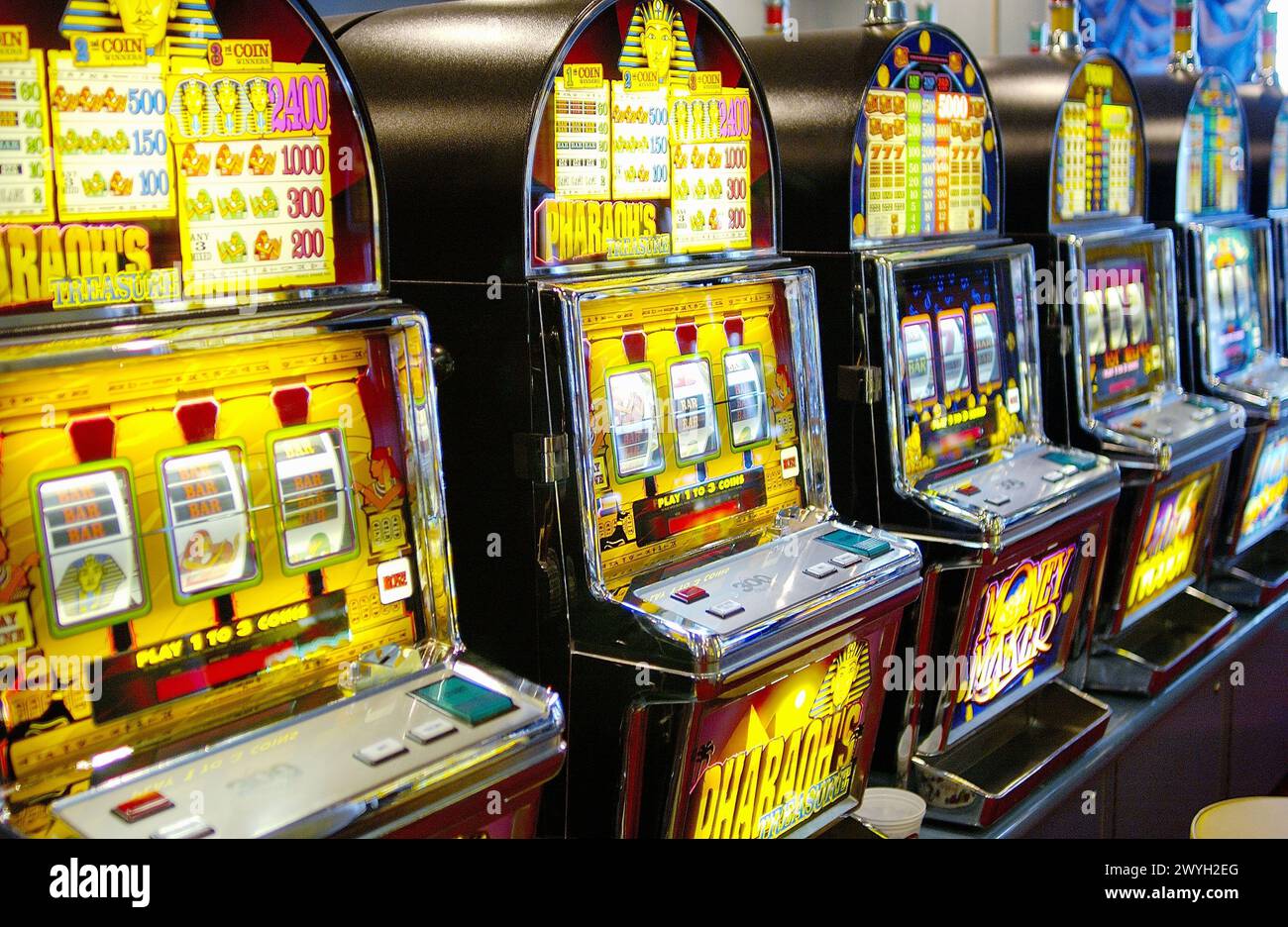 Máquinas tragamonedas clásicas y modernas en un entorno de casino, representando la transición a lo digital.