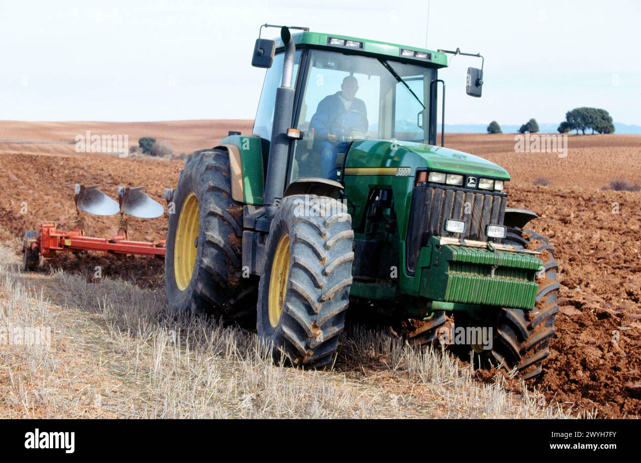Tractor dragging a plough Stock Photo - Alamy